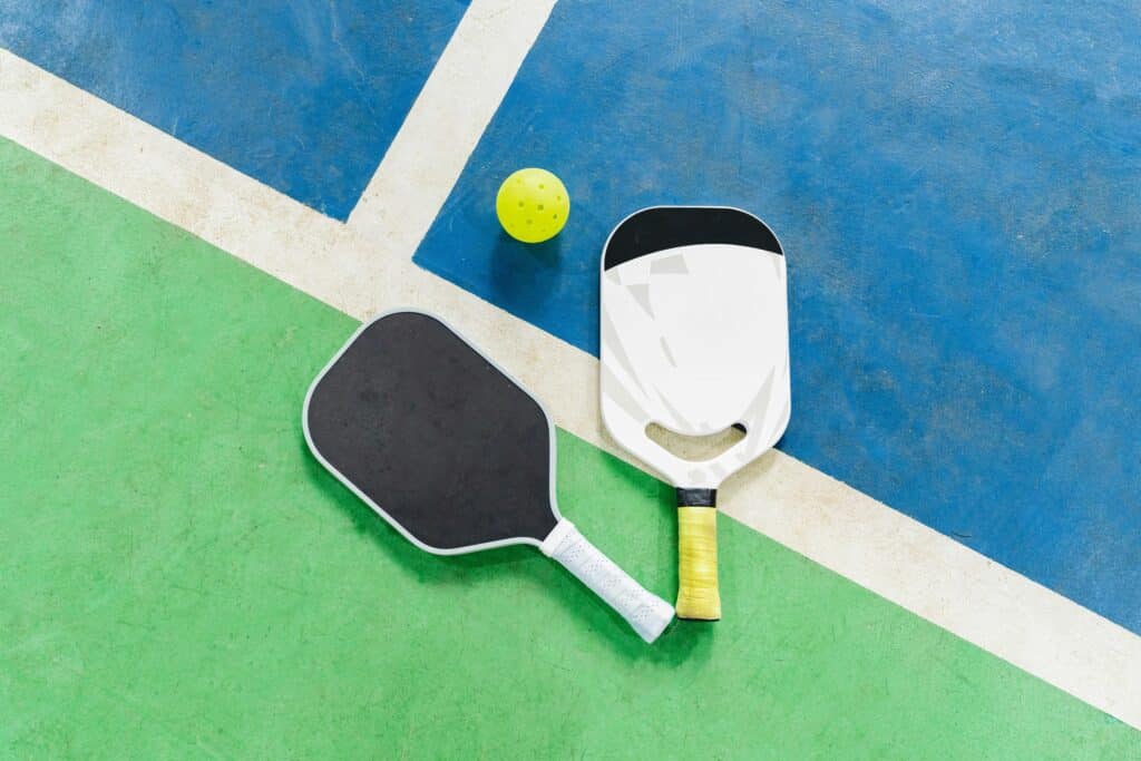 pickleball paddles and ball on a court