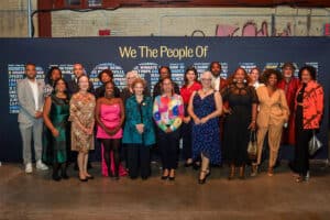 a group of people standing in front of a sign that says "we the people of brooklyn"