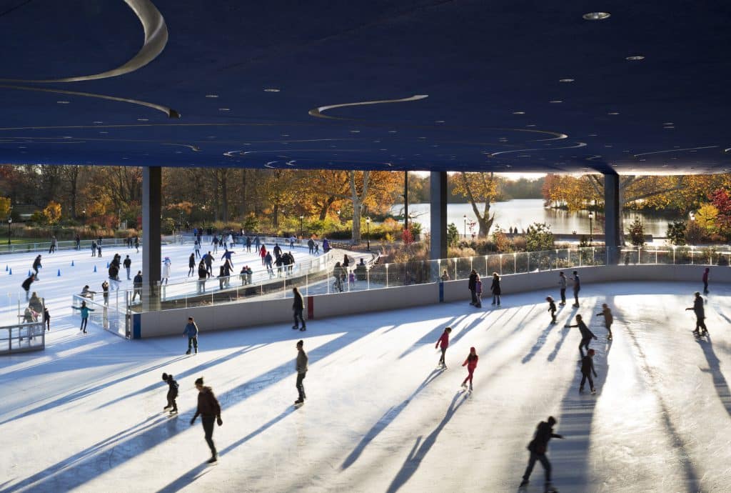 people ice skating at LeFrak Center at Lakeside in Prospect Park with fall foliage in the background